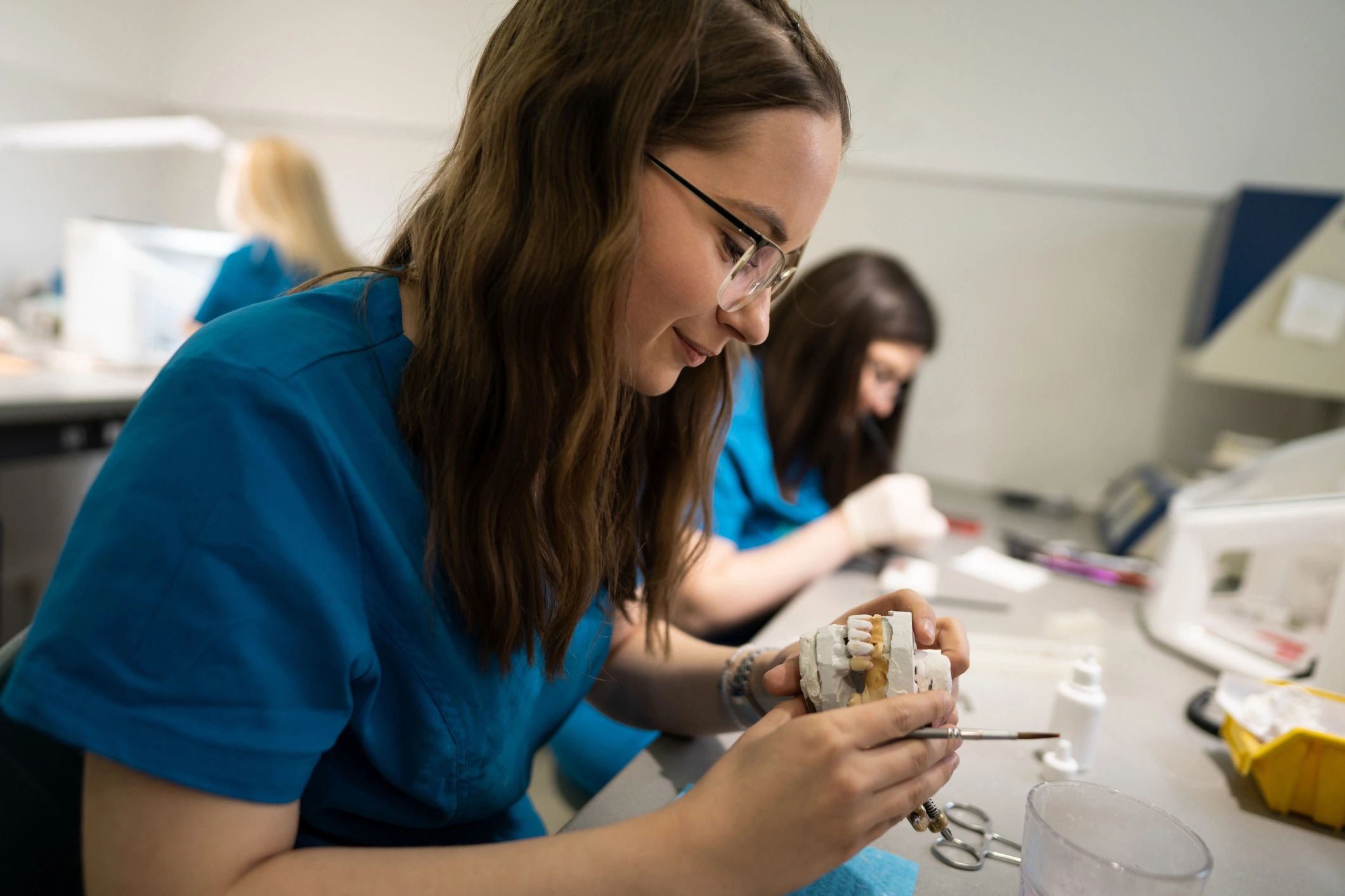 Dental laboratory technicians fabricating prosthetics at a workbench