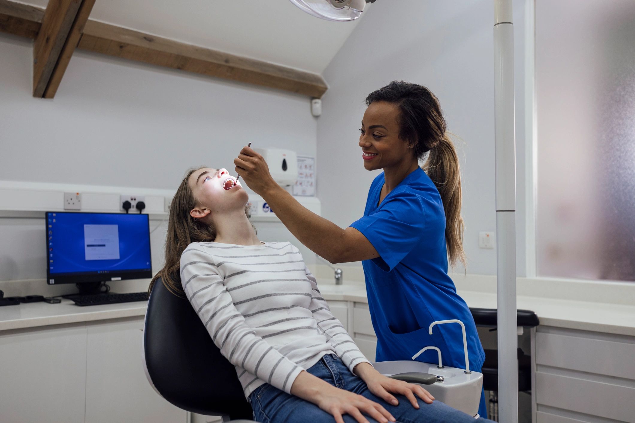 Dental clinician performing an exam in a modern operatory